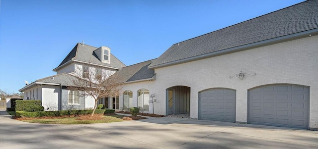 view of front of house with concrete driveway, brick siding, and an attached garage