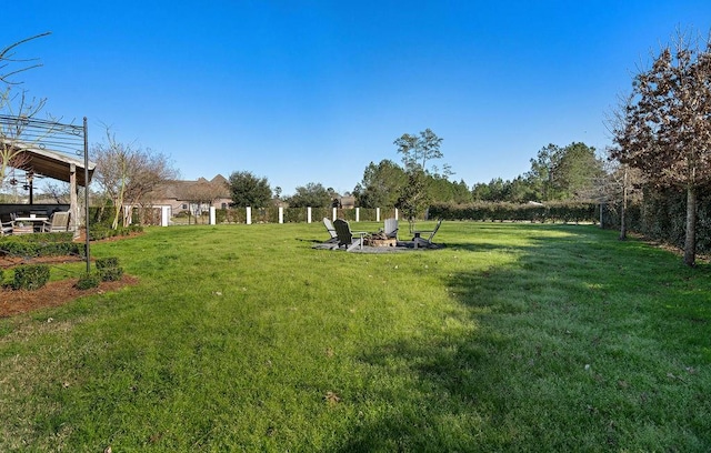 view of yard with a fire pit and fence