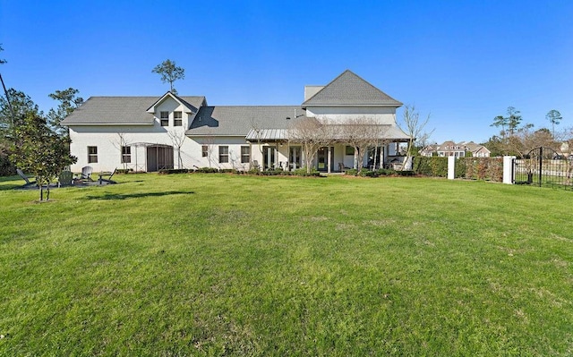 back of house featuring a yard and fence