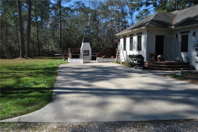 view of home's exterior featuring driveway and a yard