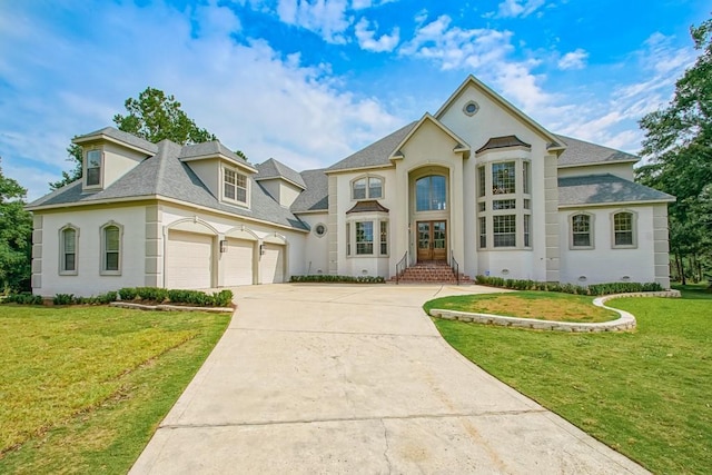 view of front of home featuring stucco siding, driveway, an attached garage, and a front yard