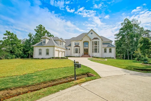 view of front of house with concrete driveway, a front lawn, and stucco siding