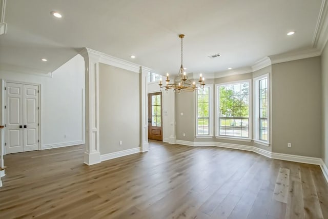 unfurnished dining area featuring visible vents, wood finished floors, recessed lighting, crown molding, and ornate columns