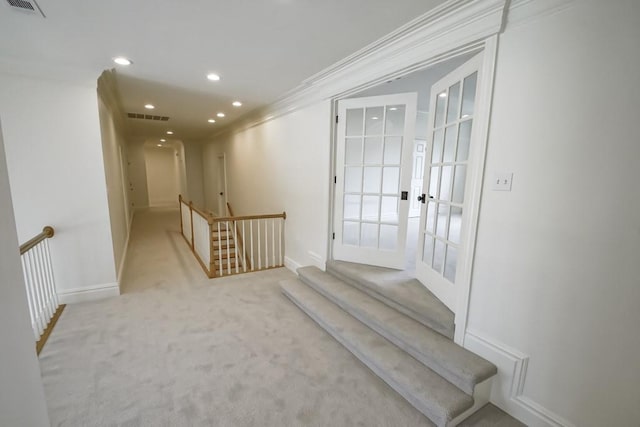 corridor featuring visible vents, ornamental molding, an upstairs landing, carpet floors, and recessed lighting