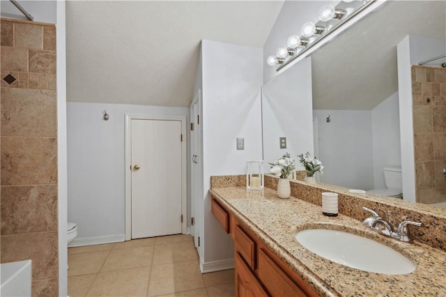 bathroom featuring lofted ceiling, vanity, toilet, and tile patterned floors