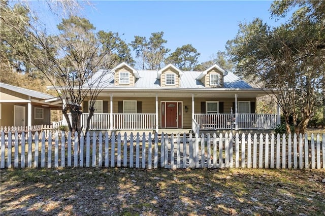 view of front facade with metal roof, a fenced front yard, and a porch