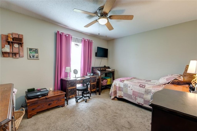 bedroom with a ceiling fan, carpet flooring, and a textured ceiling