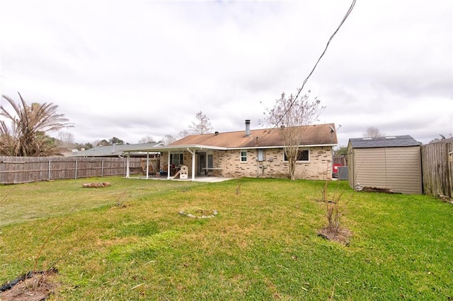 view of yard with an outbuilding, a shed, a patio area, and a fenced backyard