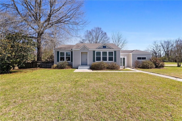 ranch-style home with fence and a front lawn