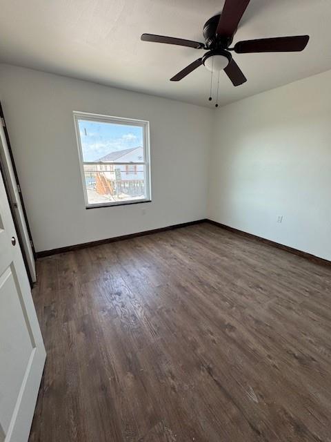 spare room featuring baseboards, ceiling fan, and wood finished floors