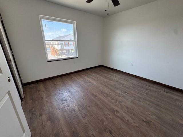 interior space with baseboards, wood finished floors, and a ceiling fan
