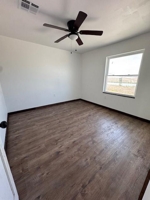 empty room featuring visible vents, baseboards, wood finished floors, and a ceiling fan