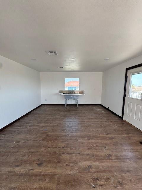 spare room with visible vents, baseboards, and wood finished floors