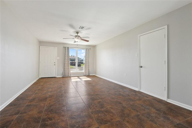 spare room featuring visible vents, ceiling fan, and baseboards