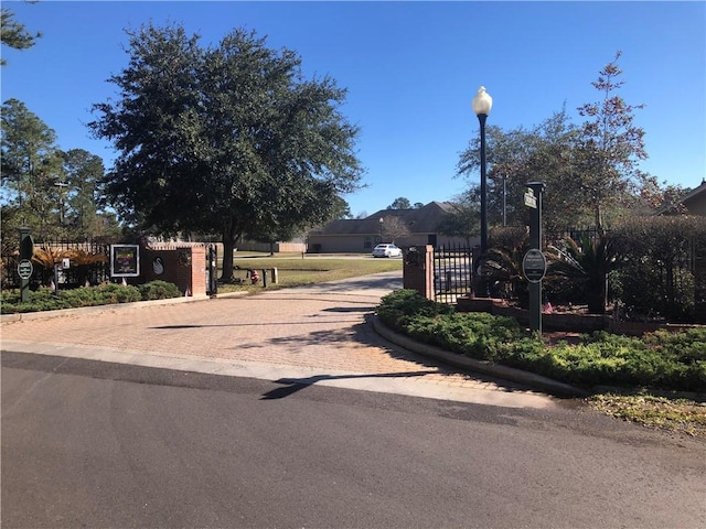 view of street featuring street lighting, a gate, and curbs