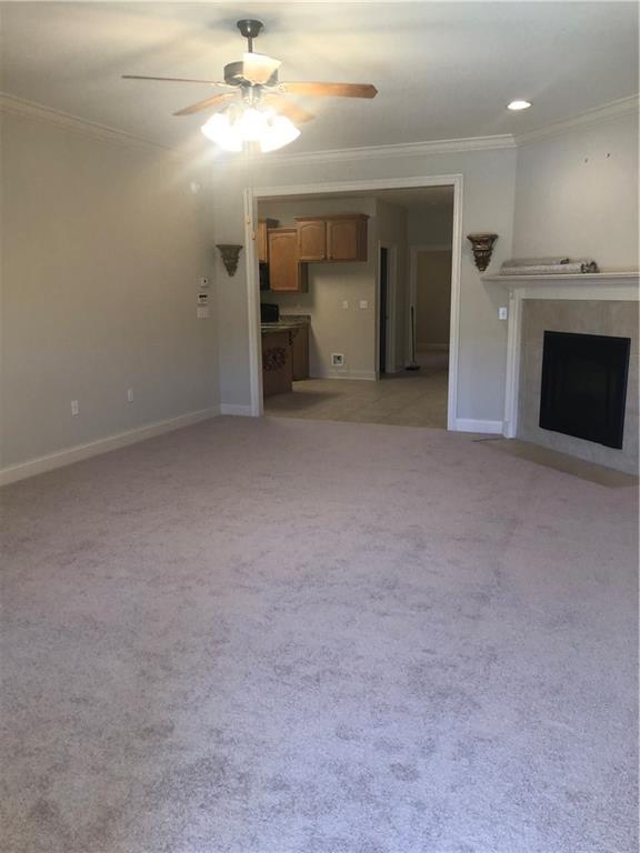 40145 Taylors Trl Unit 1002, Slidell, LA 70461 - unfurnished living room with ornamental molding, ceiling fan, a fireplace, baseboards, and light colored carpet