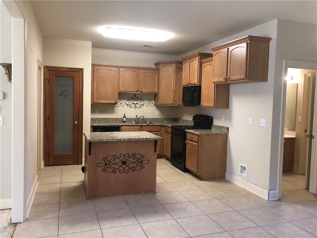 40145 Taylors Trl Unit 1002, Slidell, LA 70461 - kitchen with black appliances, dark stone countertops, a kitchen island, baseboards, and light tile patterned flooring