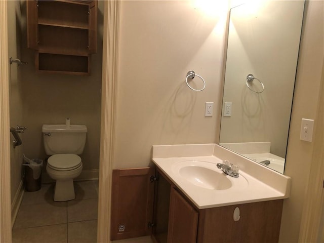 bathroom featuring toilet, tile patterned flooring, vanity, and baseboards