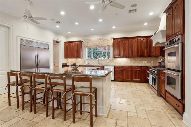 425 Turquoise St, New Orleans, LA 70124 - kitchen with visible vents, stone tile floors, ceiling fan, and premium range hood