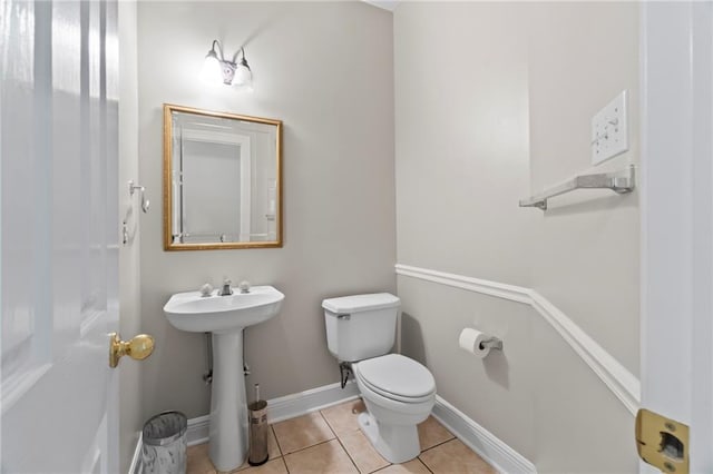 bathroom featuring baseboards, toilet, and tile patterned floors