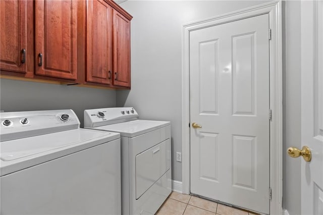 laundry room featuring light tile patterned floors, washer and clothes dryer, and cabinet space