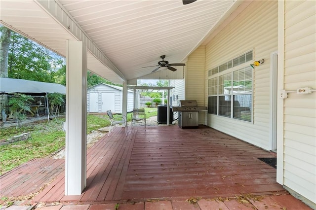 wooden deck with an outbuilding, cooling unit, a grill, a ceiling fan, and a storage unit