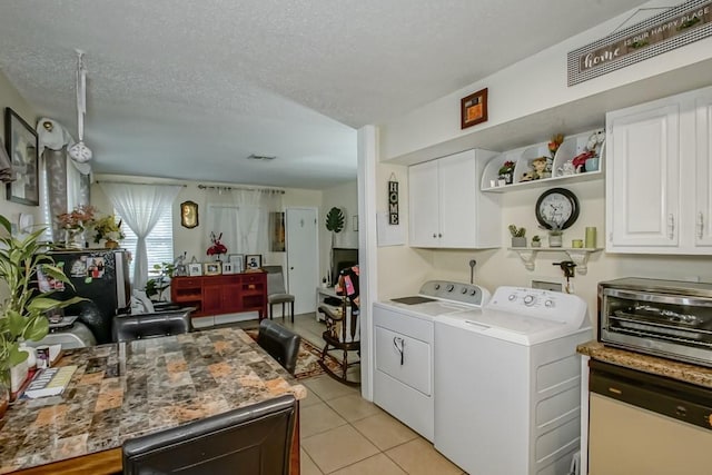 washroom featuring laundry area, light tile patterned floors, a textured ceiling, and separate washer and dryer