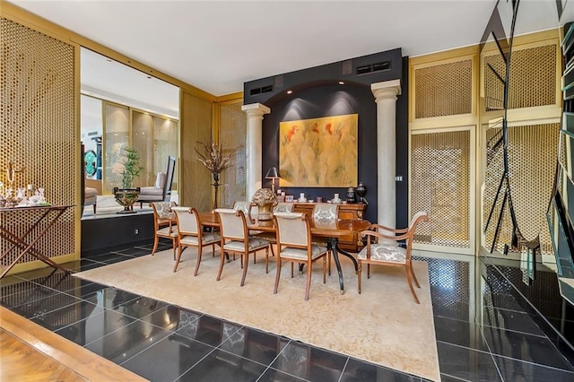 dining space featuring granite finish floor and decorative columns