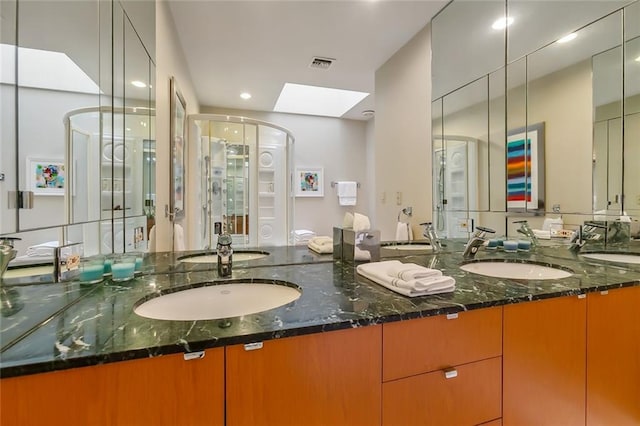 full bath with double vanity, a sink, and visible vents