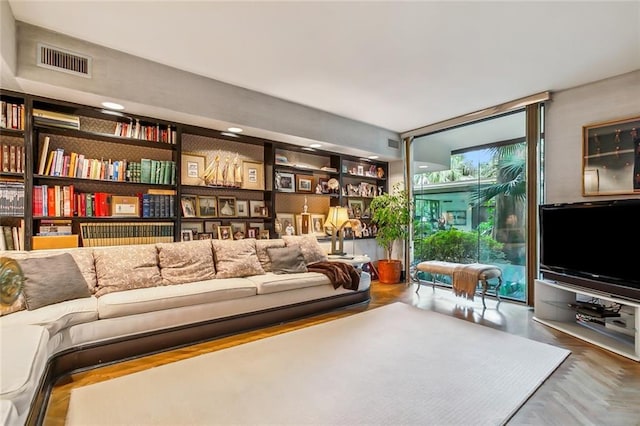 living room featuring floor to ceiling windows and visible vents