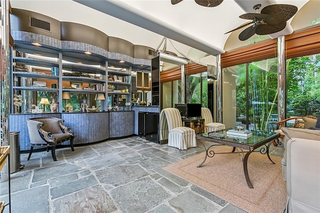 sunroom / solarium with a ceiling fan and visible vents