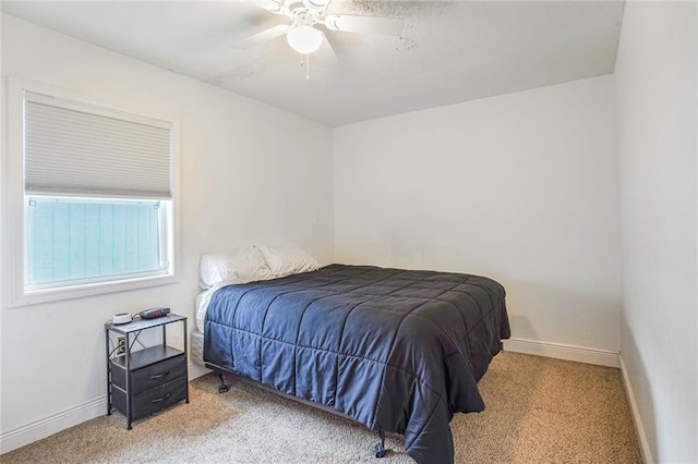 carpeted bedroom featuring ceiling fan and baseboards