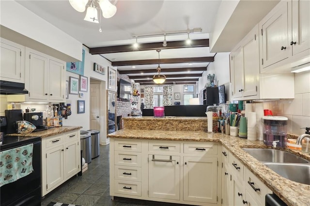 kitchen featuring white cabinets, decorative backsplash, light stone countertops, pendant lighting, and a sink