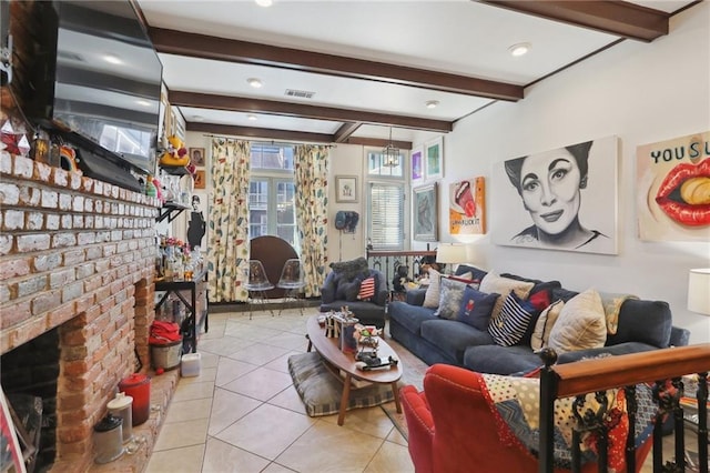 living area featuring light tile patterned floors, beamed ceiling, a brick fireplace, and visible vents