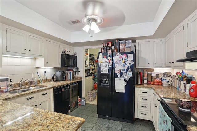 kitchen with black appliances, a sink, and white cabinetry