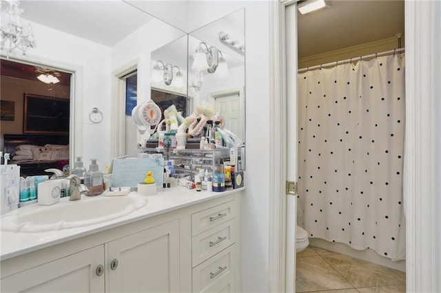 ensuite bathroom with a shower with shower curtain, toilet, connected bathroom, vanity, and tile patterned floors