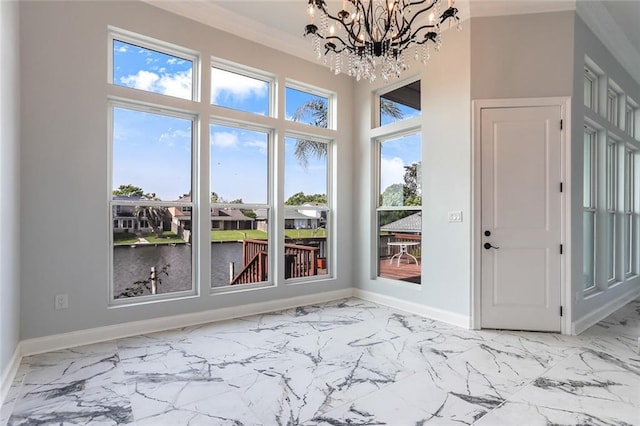 interior space with a notable chandelier, marble finish floor, crown molding, and baseboards