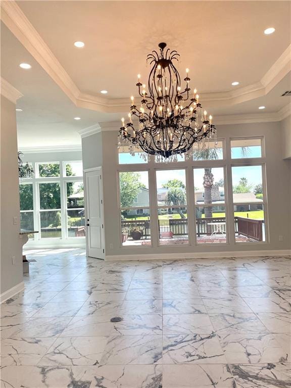 spare room with crown molding, a raised ceiling, and baseboards