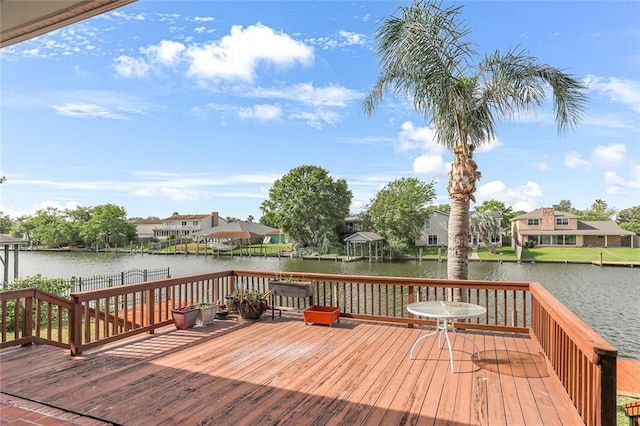 wooden terrace with a water view and a residential view