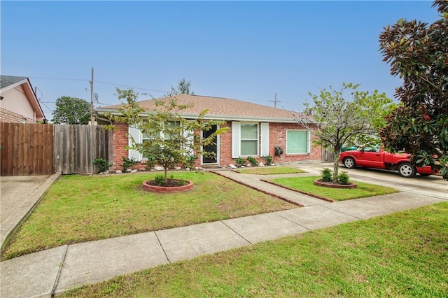 ranch-style home with driveway, brick siding, a front yard, and fence