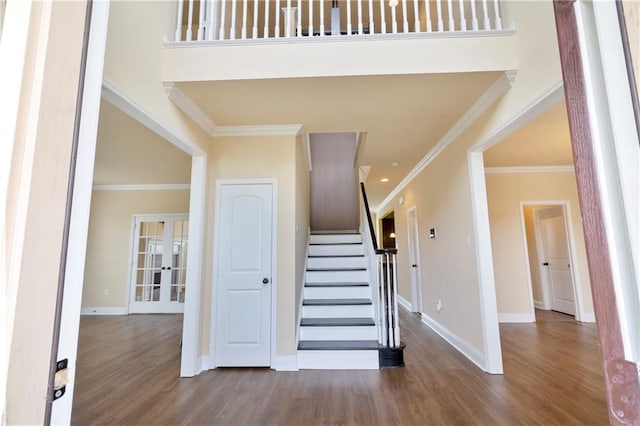 stairs featuring ornamental molding, french doors, wood finished floors, and baseboards