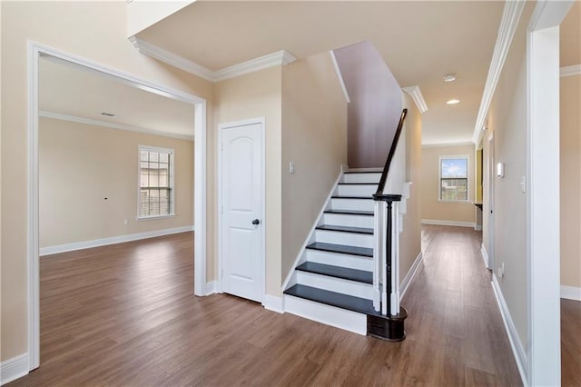 stairway featuring ornamental molding, baseboards, and wood finished floors