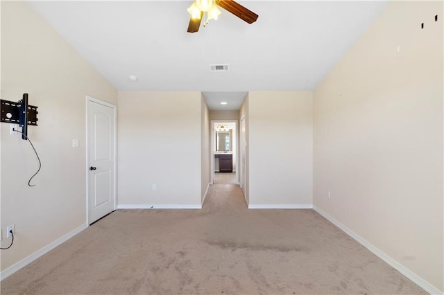 carpeted spare room featuring visible vents, ceiling fan, and baseboards