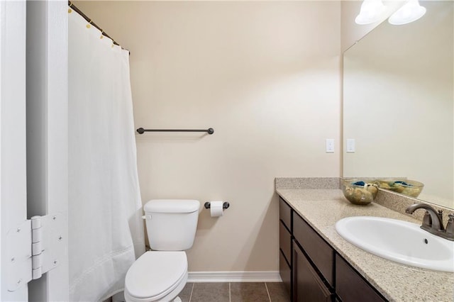 bathroom with tile patterned flooring, vanity, toilet, and baseboards