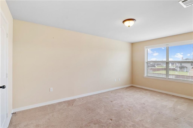 spare room with visible vents, light carpet, and baseboards