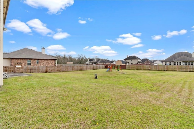 view of yard with a fenced backyard and a playground