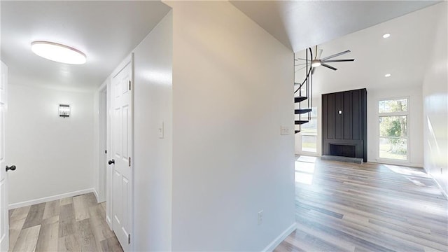 corridor with light wood-type flooring, baseboards, and recessed lighting