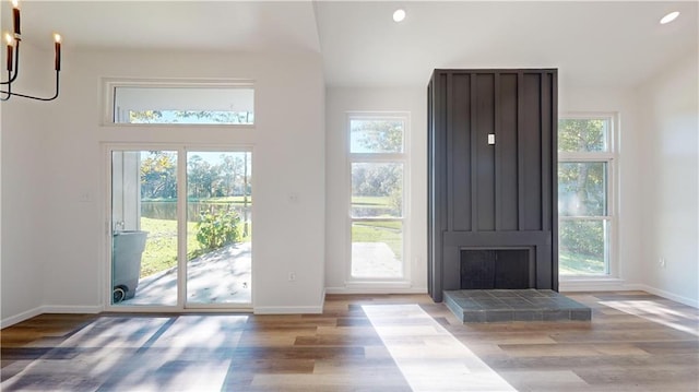 doorway to outside featuring recessed lighting, an inviting chandelier, baseboards, and wood finished floors