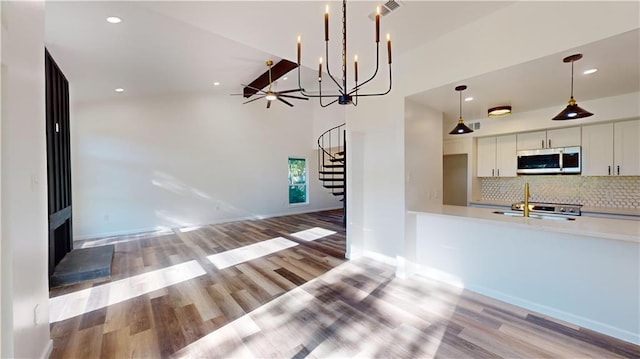 kitchen featuring light countertops, stainless steel microwave, light wood-type flooring, and backsplash