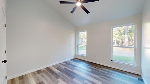 empty room featuring lofted ceiling, ceiling fan, baseboards, and wood finished floors